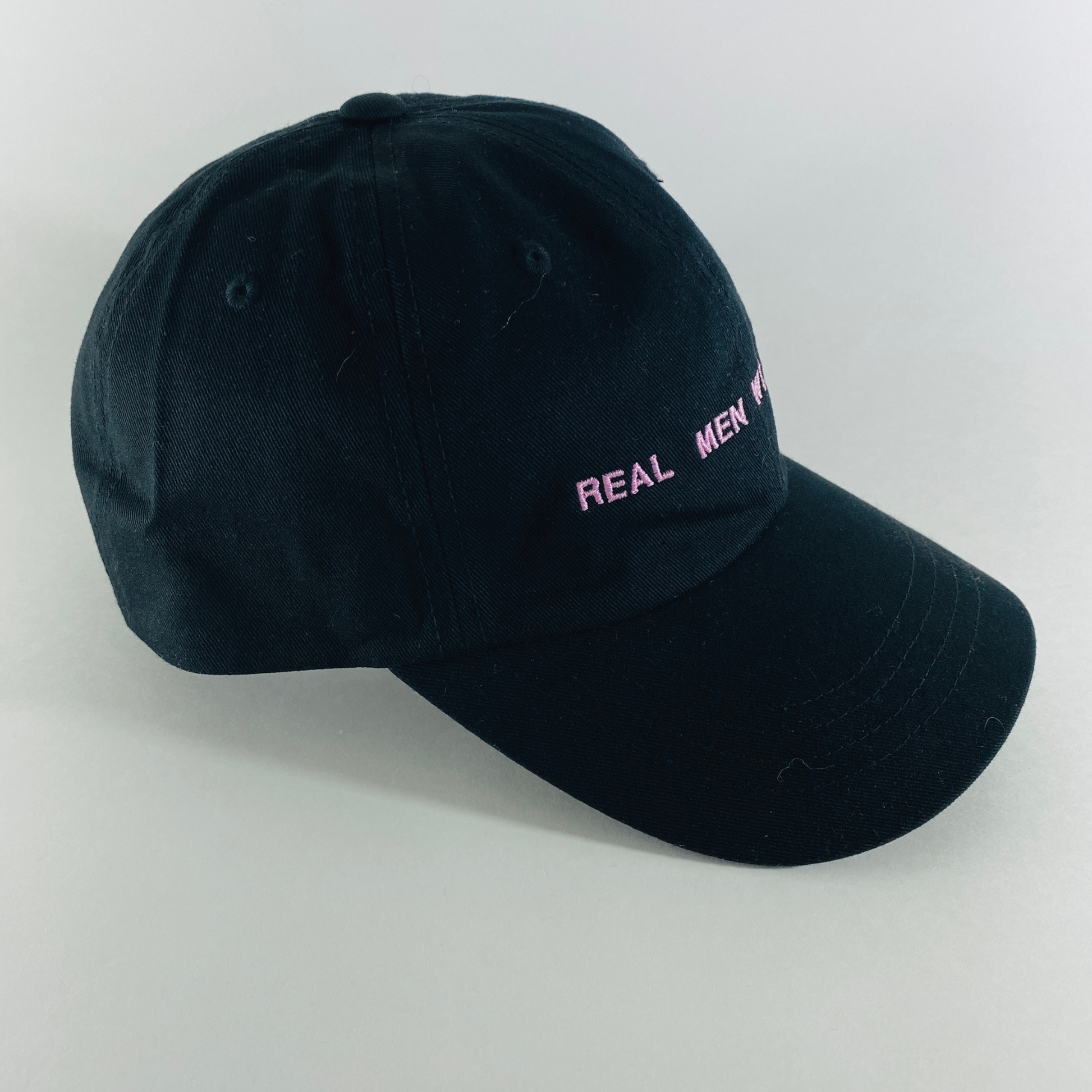 side view black dad cap with REAL MEN WEAR PINK printed on front